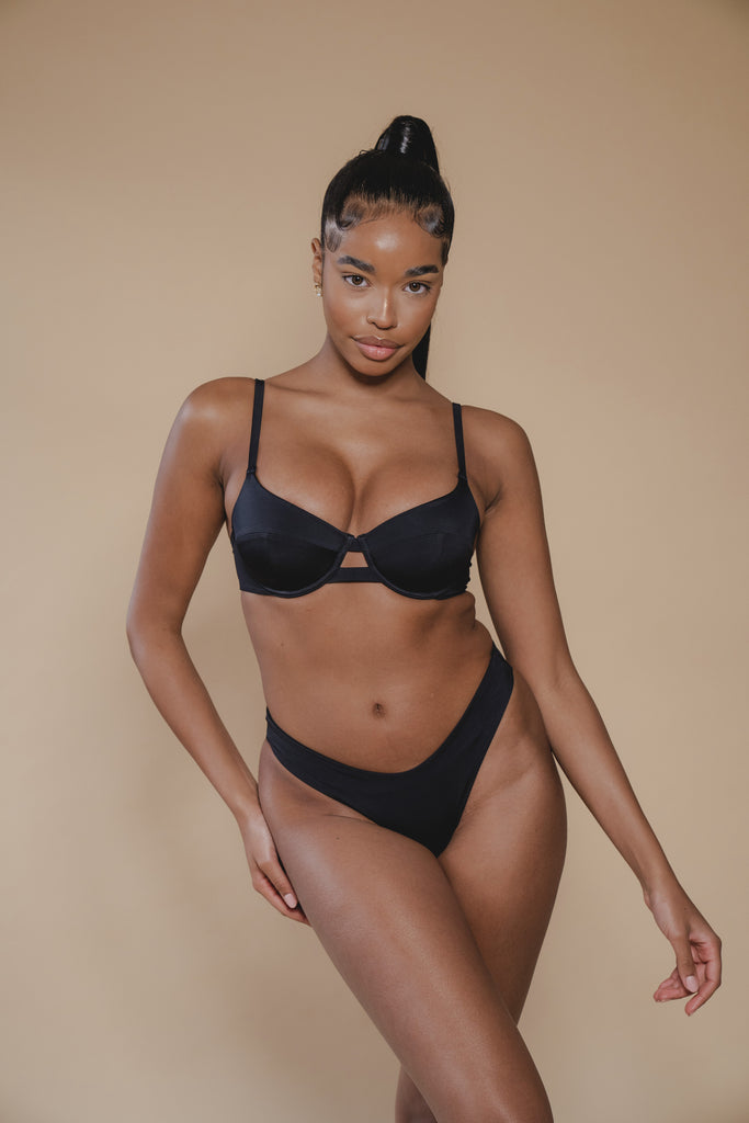 jua june sustainable swimwear black bikini top. the bra top is made of recycled material and is of high quality. black bikini top from luxury swimwear.