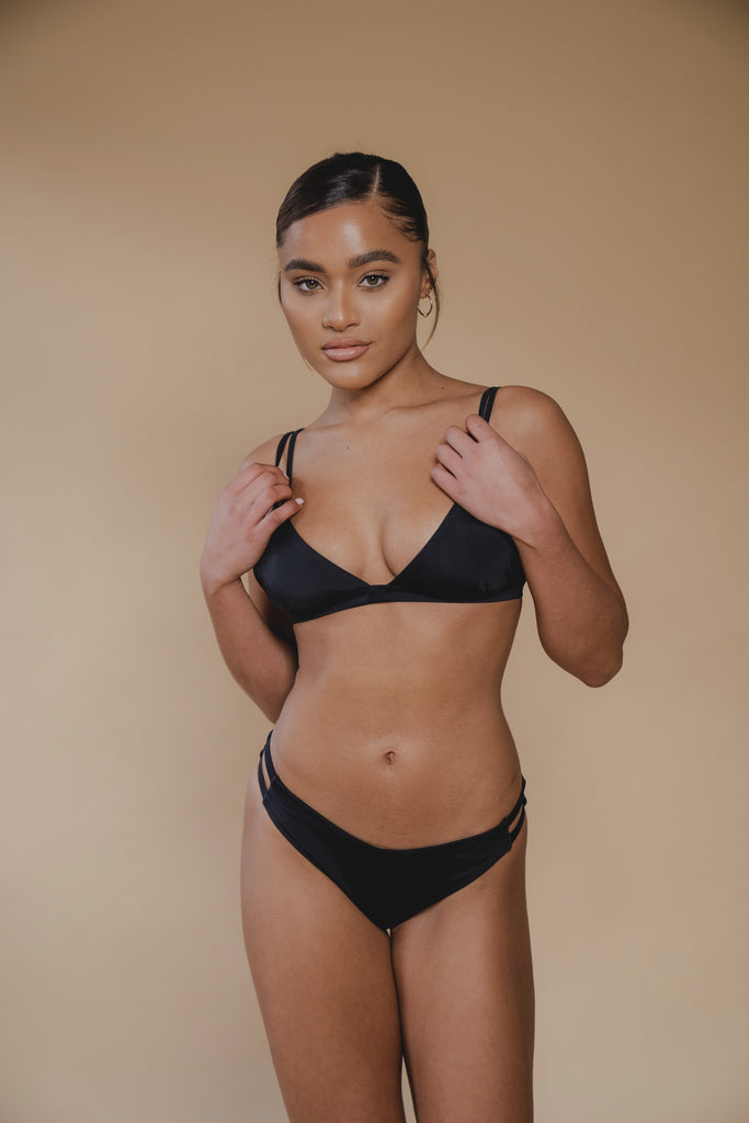 jua june sustainable swimwear. a black triangle bikini top combined with a black high leg bikini bottom. made of ecofriendly materials, high quality swimwear. luxury swimwear.